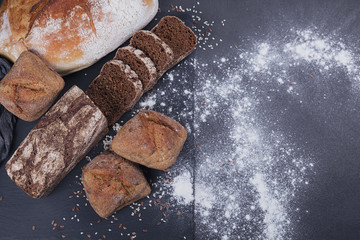 Assortment of baked bread on dark background.
