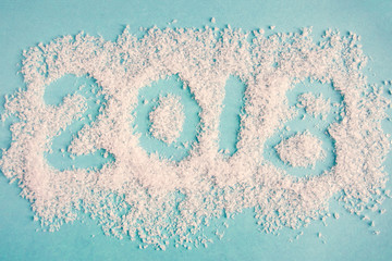 2018 made of decoration snow on pastel blue background. NEw Year concept
