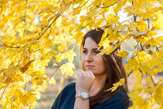 Imagined young teenage girl under a tree with a yellow leaf in autumn