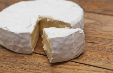 Fototapeta na wymiar French Camembert cheese on rustic wooden background