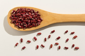 Adzuki Bean legume. Healthy grains on a wooden spoon. White background.