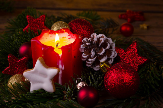 Burning advent candle with classic christmas decoration