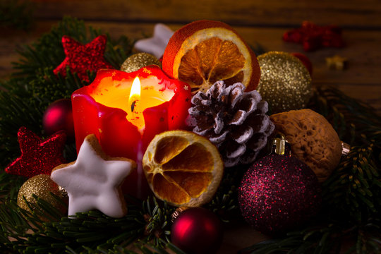 Burning advent candle with classic christmas decoration
