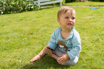 The barefoot boy is playing on the grass