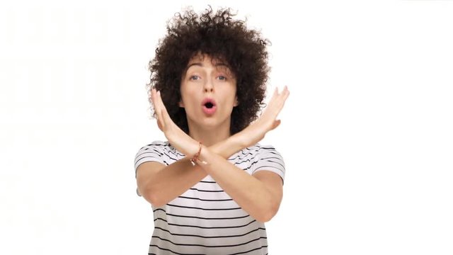 indoor portrait of strong-willed determined female person definitely being disagree making X shape with hands saying NO denying over white background. Concept of emotions
