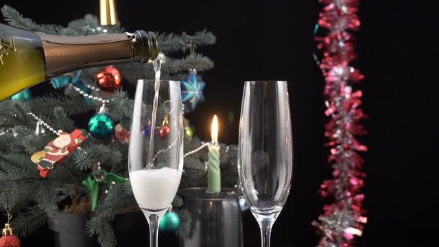 Glasses with champagne against holiday candle