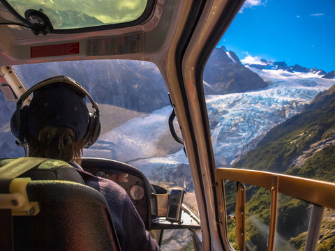 helicopter flying over glacier