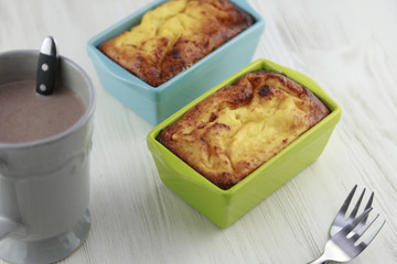 Cheese cake in cute bright turquoise and green baking dishes and a cup of cocoa