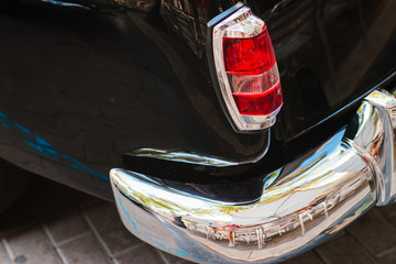 Close-up of back headlight of black vintage car.