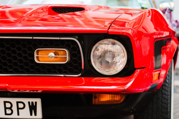 Close-up of front headlight of red vintage car