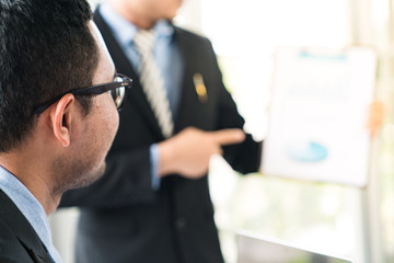 Business team during meeting conference are working documents about the marketing plan and sales profit finance of the company with laptop computer and smartphone tablet on work table
