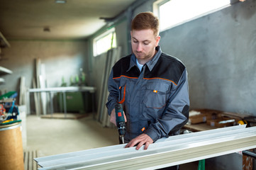 Worker with drilling mashine in workshop
