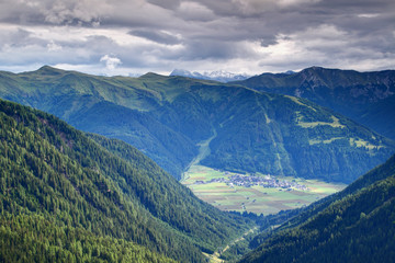 Obertilliach village in Lesachtal valley with Golzentipp ski resort in Gailtal Alps, and snowy Prijakt peak, Schober group, Hohe Tauern, from Tilliacher Joch, Carnic Alps, East Tyrol, Austria, Europe