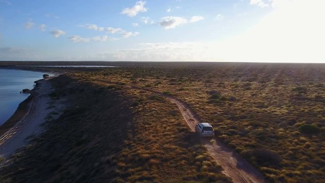 Aerial view of 4x4 car driving off road through wilderness