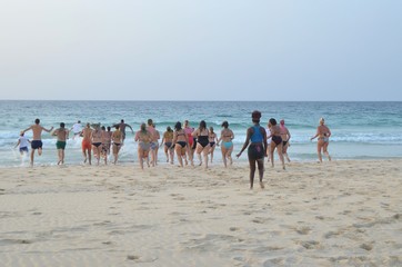 Plage du Cap-Vert, touristes courant sur la plage pour se jeter à l'eau