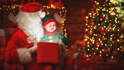 Fototapeta na wymiar Santa Claus and little elf with magic gift for Christmas