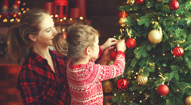 happy family mother and child girl decorated Christmas tree