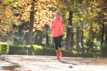 Fototapeta na wymiar attractive and happy runner woman in Autumn sportswear running a