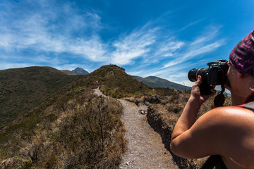 A woman climber takes photos of the Andean landscape