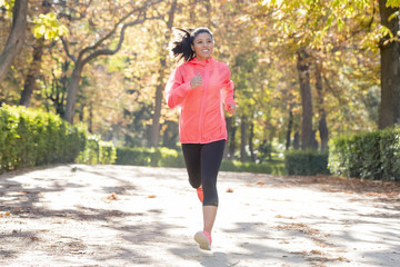 attractive and happy runner woman in Autumn sportswear running a