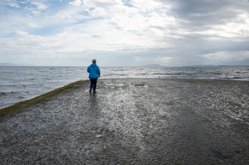 Woman standing at end of boat ramp. Point Holmes ~ Vancouver Island, British Columbia, Canada
