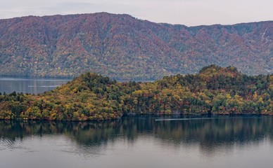 Towada lake and sight seeing boat cruising during autumn season, Akita, Japan.