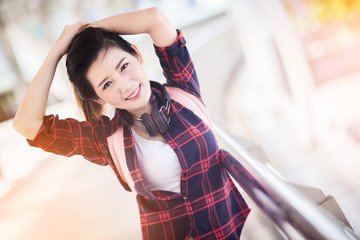 beautiful happiness young asian girl in casual dress traveling alone at train station or airport with backpack vintage tone photo concept