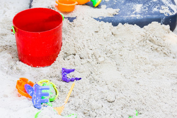 Plastic toys sand on the sea beach background.