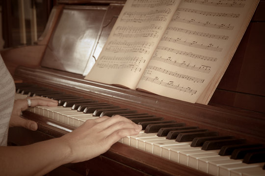woman's hands playing the piano