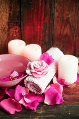 Spa settings with roses. Fresh roses and rose petals in a bowl of water and various items used in spa treatments