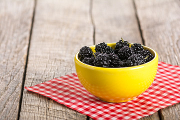 Ripe black mulberry in ceramic bowl