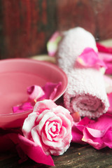 Obraz na płótnie Canvas Spa settings with roses. Fresh roses and rose petals in a bowl of water and various items used in spa treatments