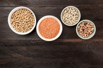 Legumes on dark background, from above with copy space