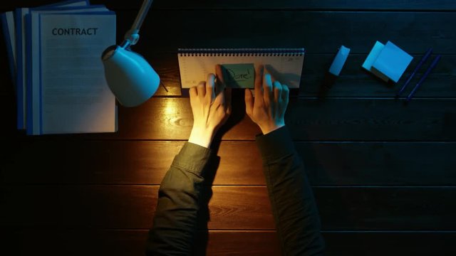 A man is sitting at an office desk and using a phone.