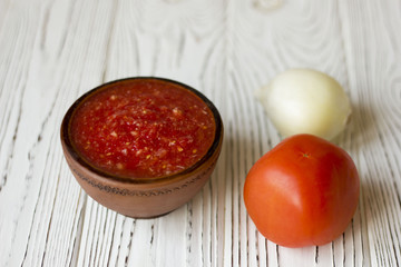 vegetarian dishes and vegetables - tomato, onion on a wooden table