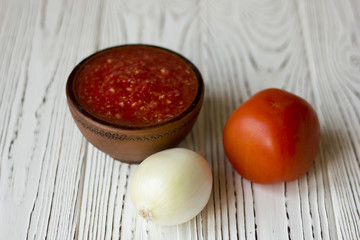 vegetarian dishes and vegetables - tomato, onion on a wooden table