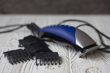 electric clipper hair clipper and attachments on wooden background