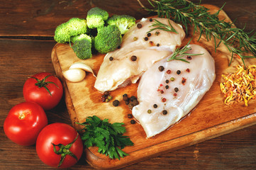 Raw chicken breast with vegetables ingredients in a cast iron skillet. Cooking
