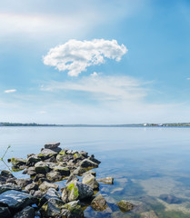 stones in river and blue sky with clouds over it