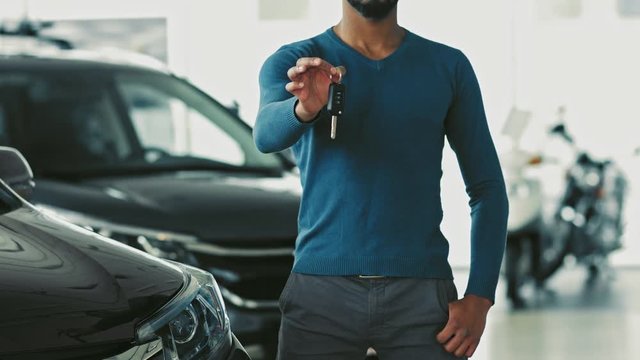 Happy male car owner showing keys to his new auto