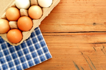 Egg carton with  blue napkin on wood board,top view  for copy text space