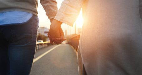 Happy couple holding hands in the sunset