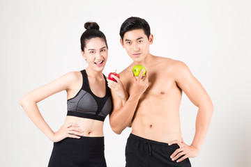 Sportsman and sport girl Bites Green Apple After Training. Fitness and healthy lifestyle concept. Studio shot on white background.