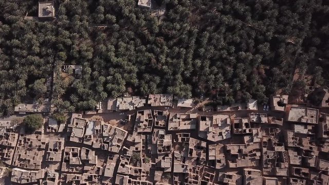 Aerial view from a drone flying over an ancient Omani village settled among date palm trees. Al Hamra, Oman.