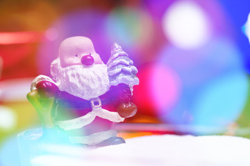 Fototapeta na wymiar Blurry background with Santa claus toy and colorful lighting