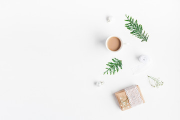 Christmas composition. Cup of coffeee, christmas gift, thuja branches on white background. Flat lay, top view, copy space