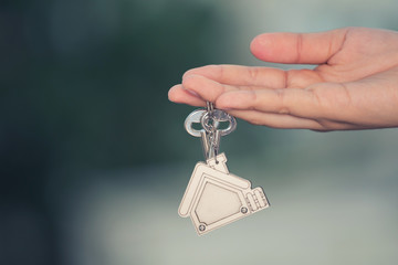 Fototapeta na wymiar Woman hand holding home key. Concept for real estate business.