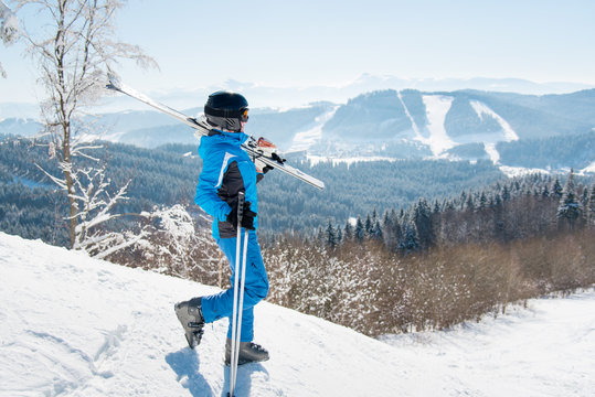 Full length shot of a female skier walking down the slope with her skis on the shoulder copyspace