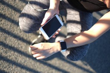 Fitness woman hand wearing  smart watch and using mobile phone o