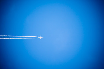 plane isolated flying high above in blue sky, travel concept